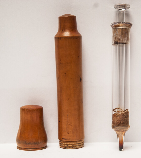 A 19th century glass syringe in its original boxwood container.