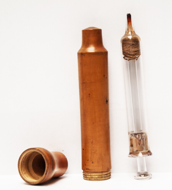 A 19th century glass syringe in its original boxwood container.