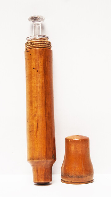 A 19th century glass syringe in its original boxwood container.