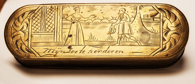 A brass 17th C. Dutch tobacco box with a naughty text.