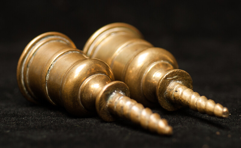 A pair of early seventeenth century brass church bench candle sticks.