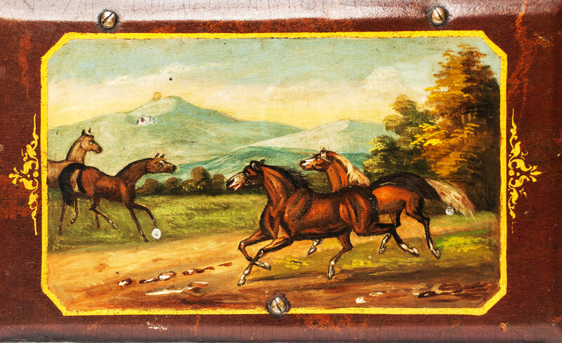 A paper mache tobacco box with a beautifully painted landscape with horses.