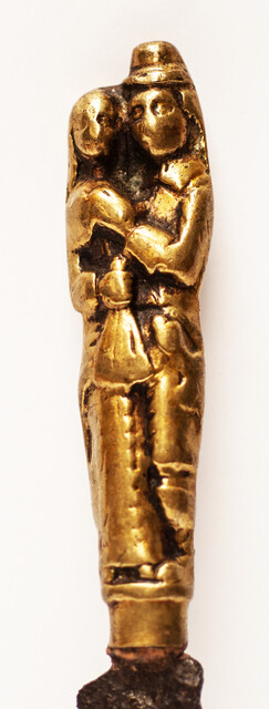 A seventeenth century knife with a brass handle showing a lady and a gentleman.