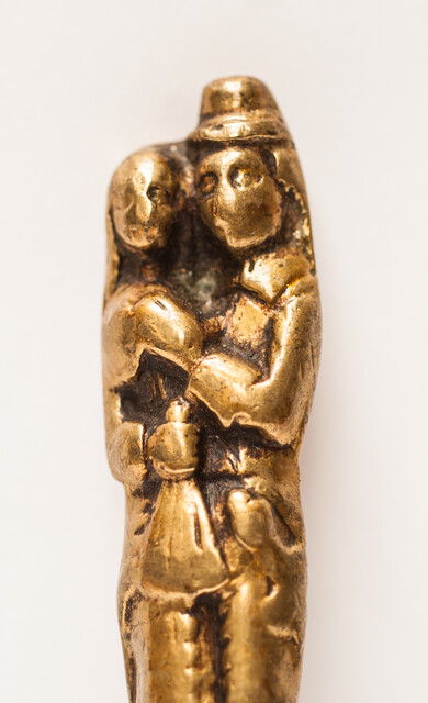 A seventeenth century knife with a brass handle showing a lady and a gentleman.