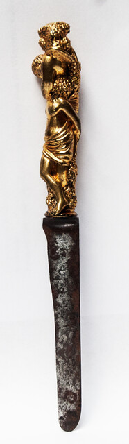 A seventeenth century knife with a brass handle showing two embracing angels.