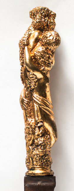 A seventeenth century knife with a brass handle showing two embracing angels.