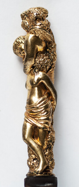 A seventeenth century knife with a brass handle showing two embracing angels.