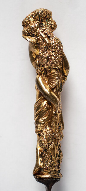 A seventeenth century knife with a brass handle showing two embracing angels.