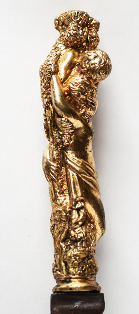 A seventeenth century knife with a brass handle showing two embracing angels.