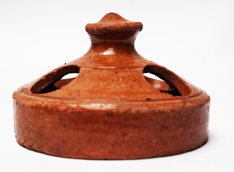 An earthenware nineteenth century chicken feeder.