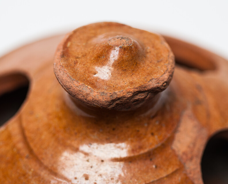 An earthenware nineteenth century chicken feeder.