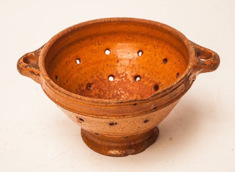 An eighteenth century glazed earthenware strawberry strainer made in Bergen Op Zoom.