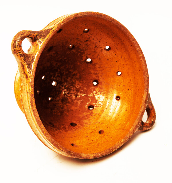 An eighteenth century glazed earthenware strawberry strainer made in Bergen Op Zoom.