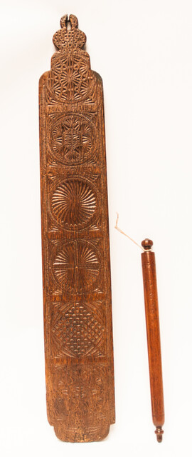 An oak Frisian mangleboard with kerbschnitt and dated 1665. With rosewood manglestick.