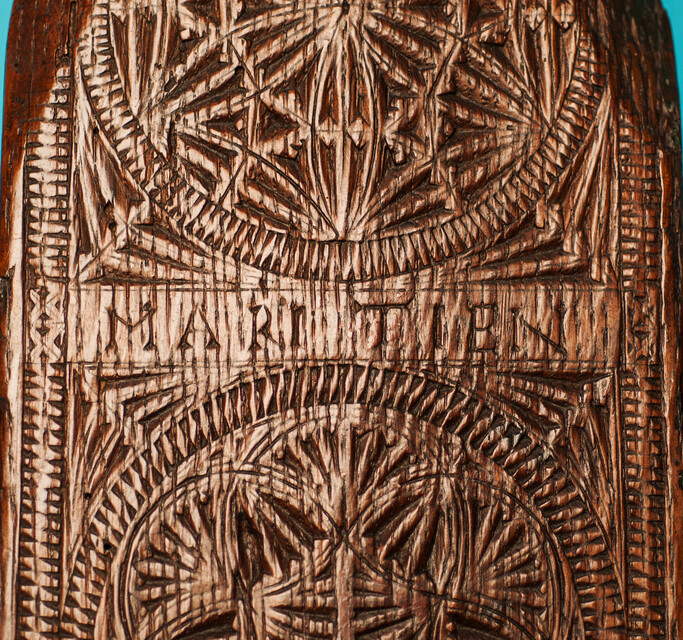 An oak Frisian mangleboard with kerbschnitt and dated 1665. With rosewood manglestick.