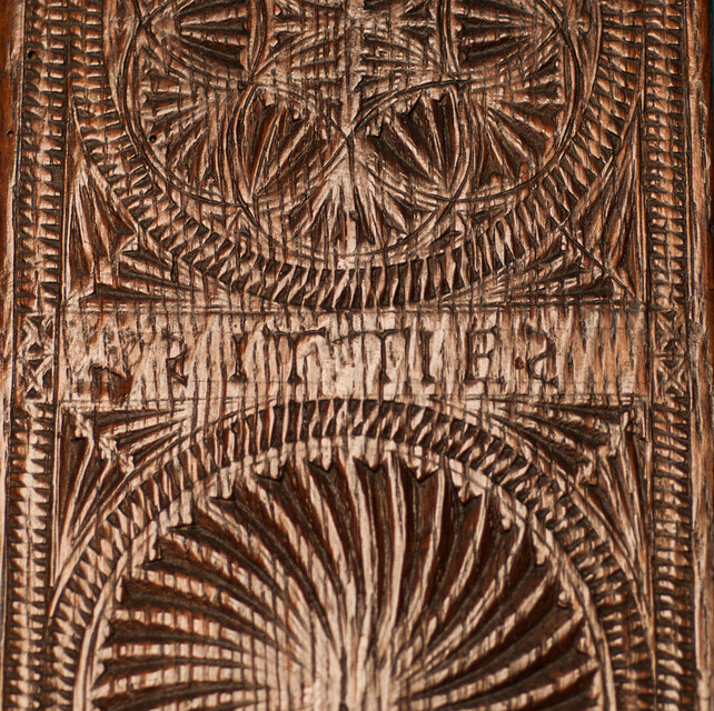 An oak Frisian mangleboard with kerbschnitt and dated 1665. With rosewood manglestick.