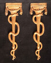 Two gilt brass aesculapes from a nineteenth century Dutch pharmacy shop.